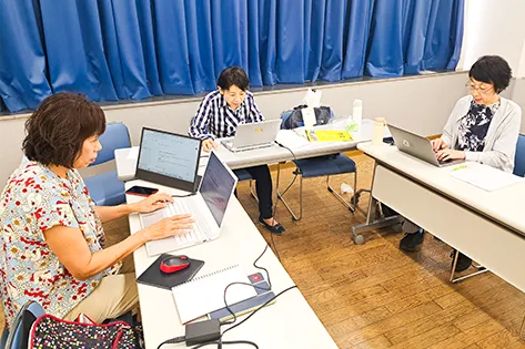 ノートパソコンで通訳の仕事をしている人たち