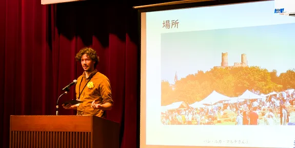 演壇に立って講習をしている外国人男性