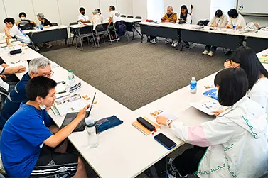 円卓状で勉強をしている子どもと大人たち